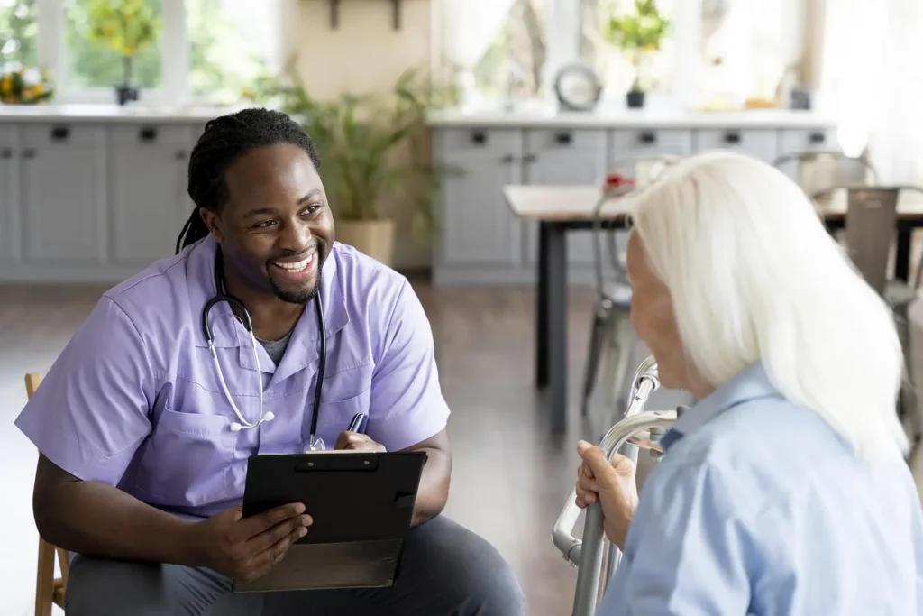 Social worker smiling while taking care of a senior woman.